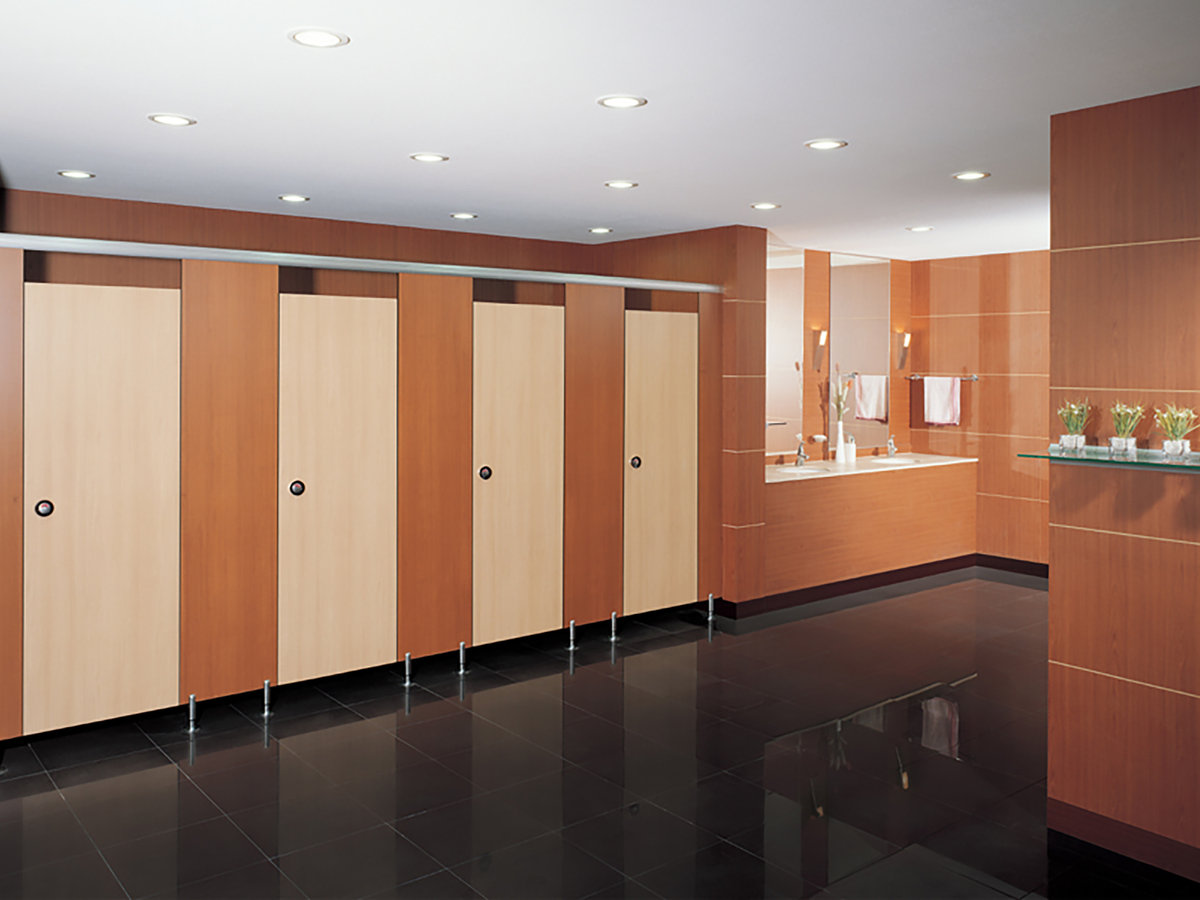 Light cubicle doors with warm-toned partitions and floor supports.
