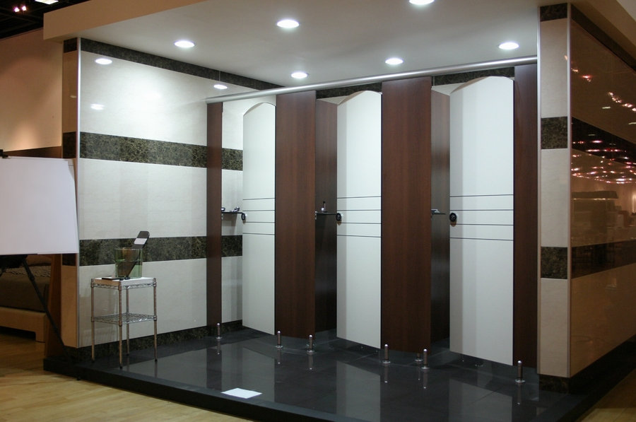 Dark-framed washroom cubicle configuration showing doors, partitions, hardware and floor supports.