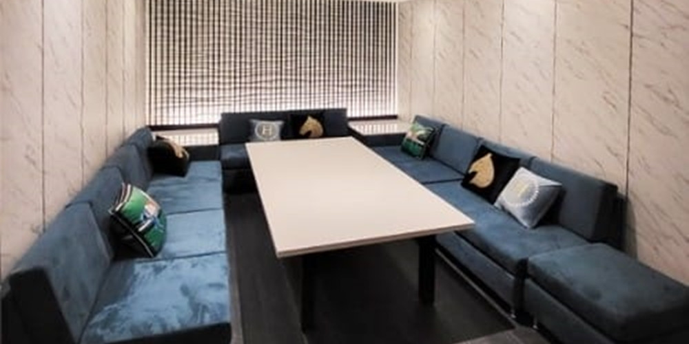 Pale patterned wall panels surrounding a blue upholstered seating area