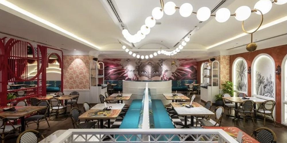 Restaurant dining room with tables arranged around a long central banquette