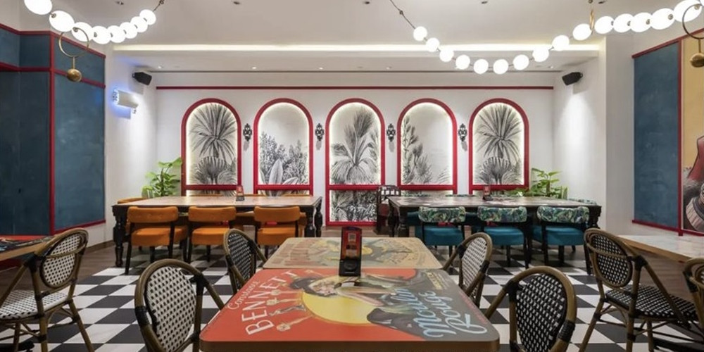 Graphic restaurant tabletop in front of a row of botanical wall panels
